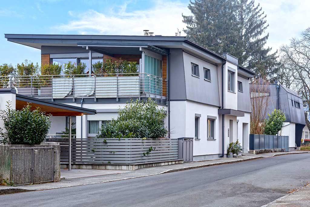 Modernes zweistöckiges Haus mit weißer Fassade, Holzakzenten und großem Balkon mit Pflanzen © SARA BUBNA photography