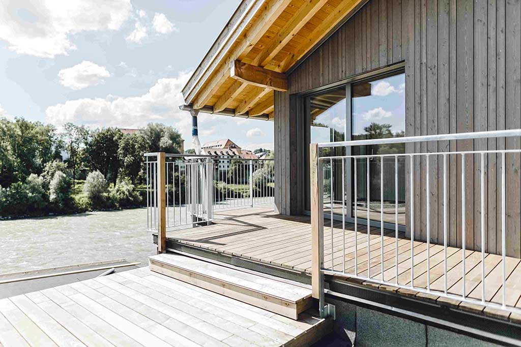 Modernes Holzgebäude mit Terrasse und Blick auf den Fluss Salzach