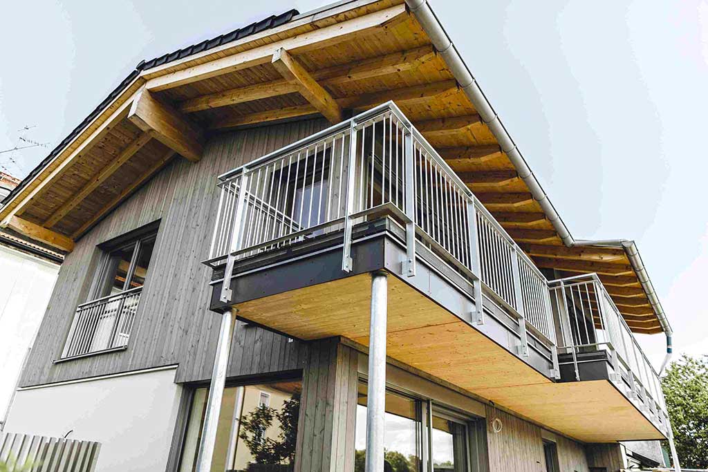 Modernes zweistöckiges Holzhaus mit großem Balkon und schrägem Dach